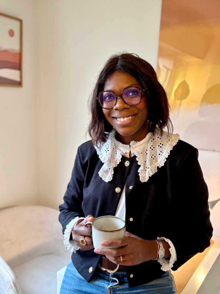 Stéphanie sourit posément appuyé à son bureau